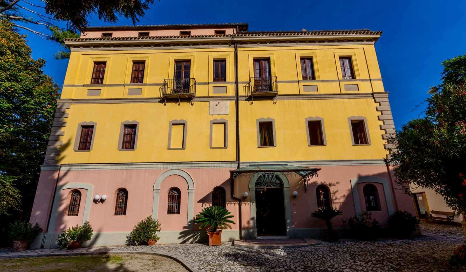 Un bâtiment à deux étages, avec une façade jaune et une partie inférieure rose.