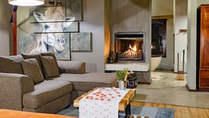 Ein Wohnzimmer mit Ecksofa, Kamin und Wandbildern.