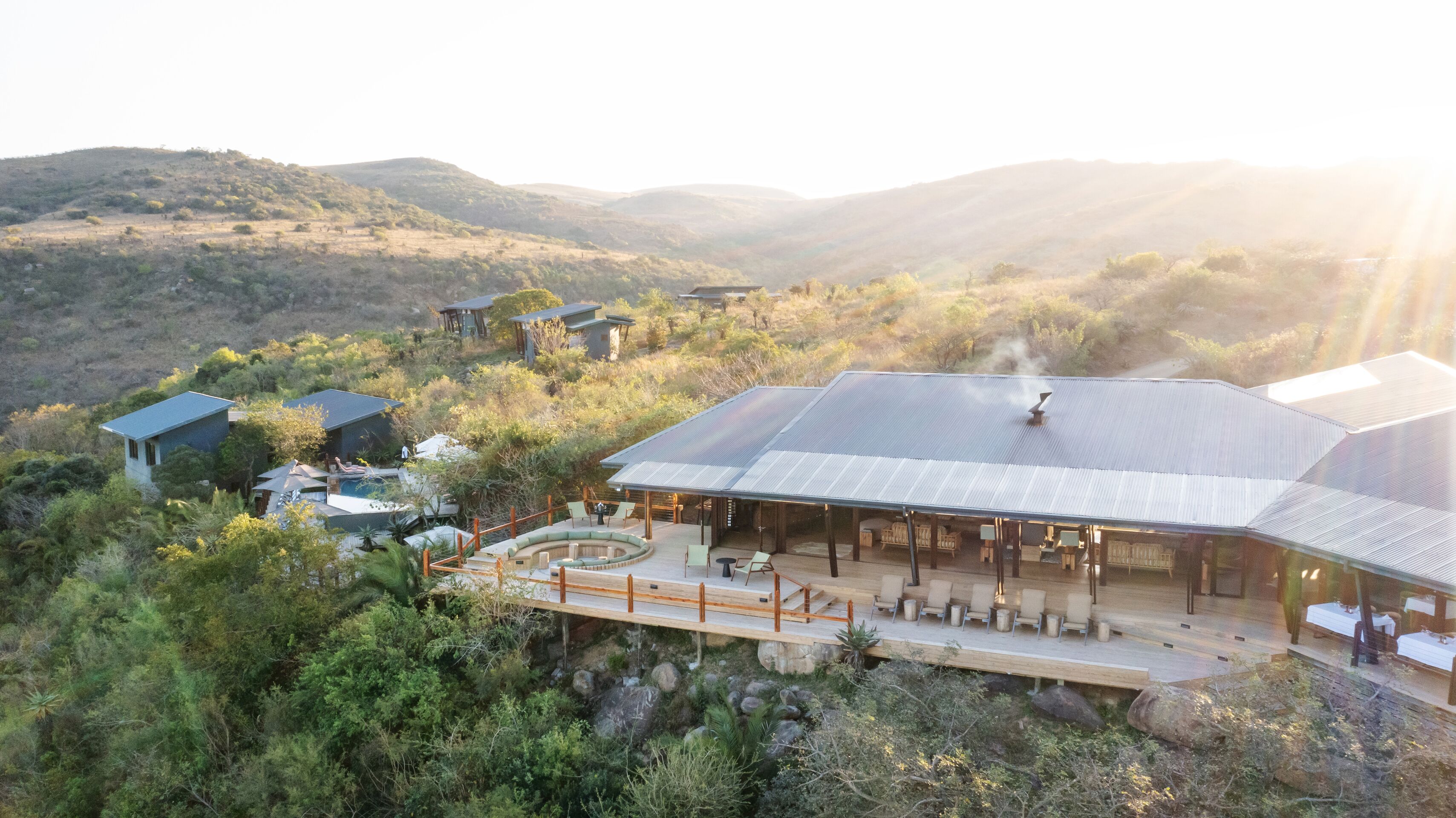 A resort with a large building, outdoor seating, and a pool.