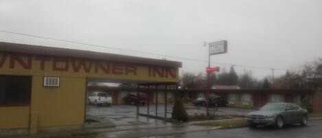 Ein Motel mit gelber Fassade, einem Schild und einem Parkplatz mit mehreren Autos.