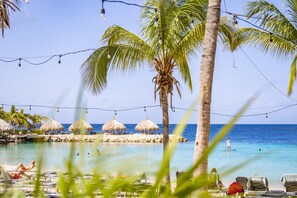 Plage, sable blanc, chaises longues, parasols