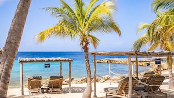 On the beach, white sand, sun loungers, beach umbrellas