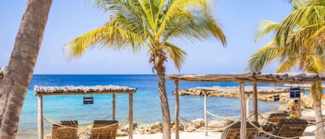 On the beach, white sand, sun-loungers, beach umbrellas