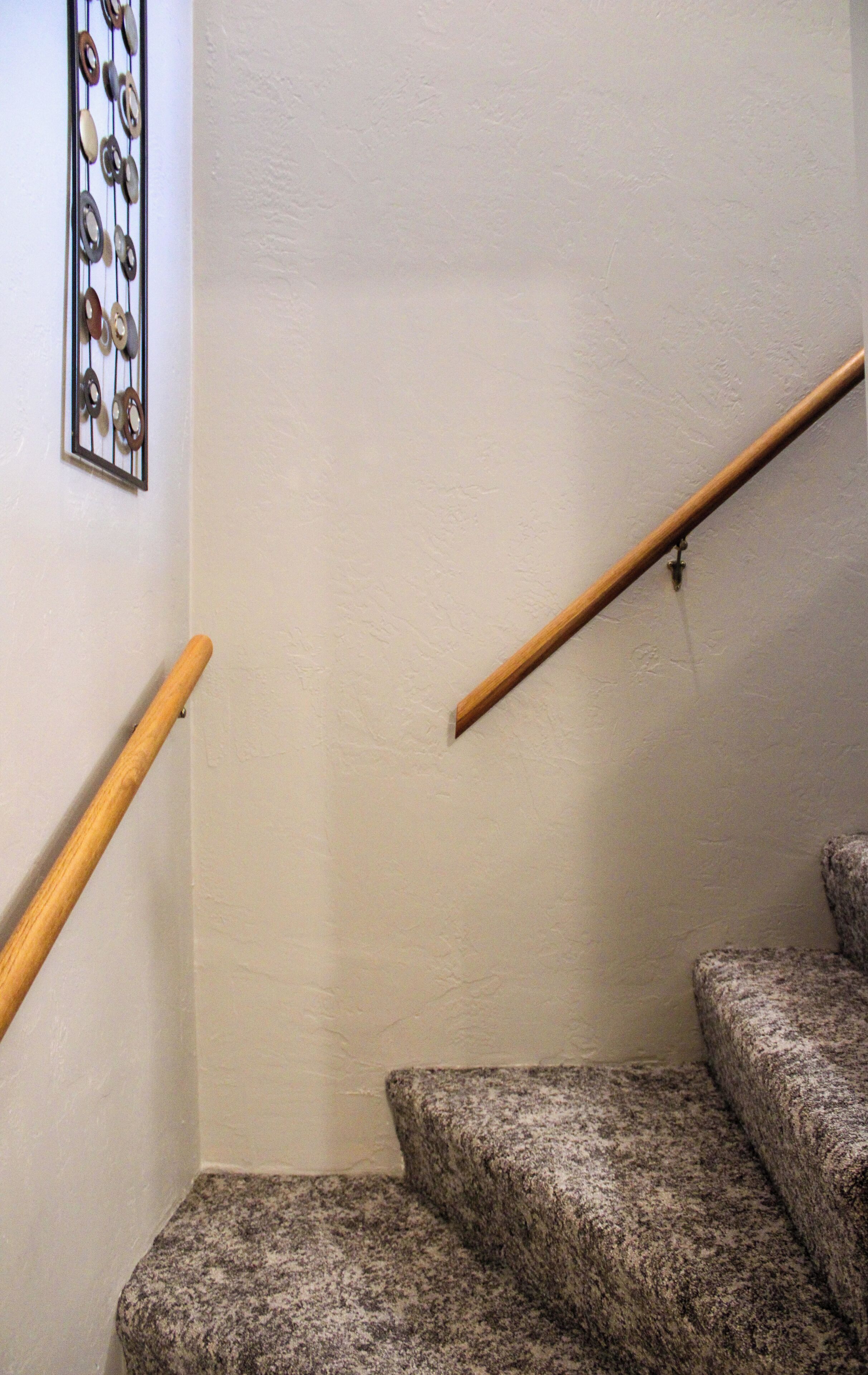 A staircase with wooden handrails and carpeted steps.