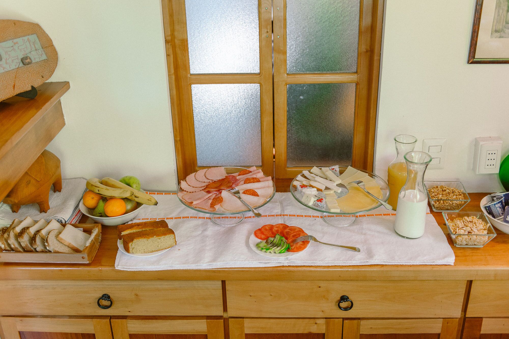 A breakfast buffet with various food items and a window in the background.