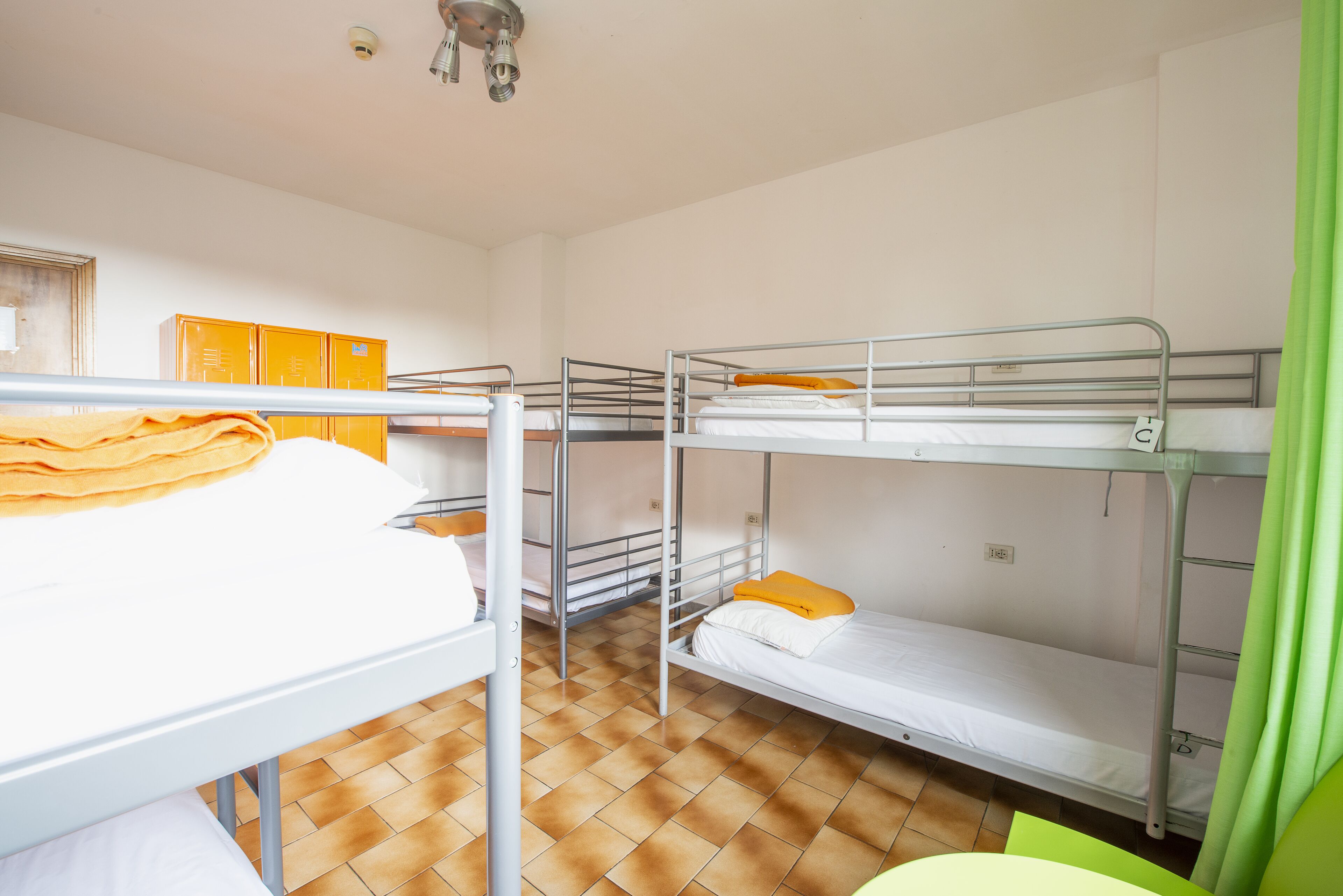 Un dormitorio con literas, una mesa y un armario.