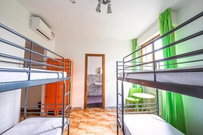 A dormitory room with bunk beds, a small table, and chairs. - Safestay Pisa Centrale (Pisa)