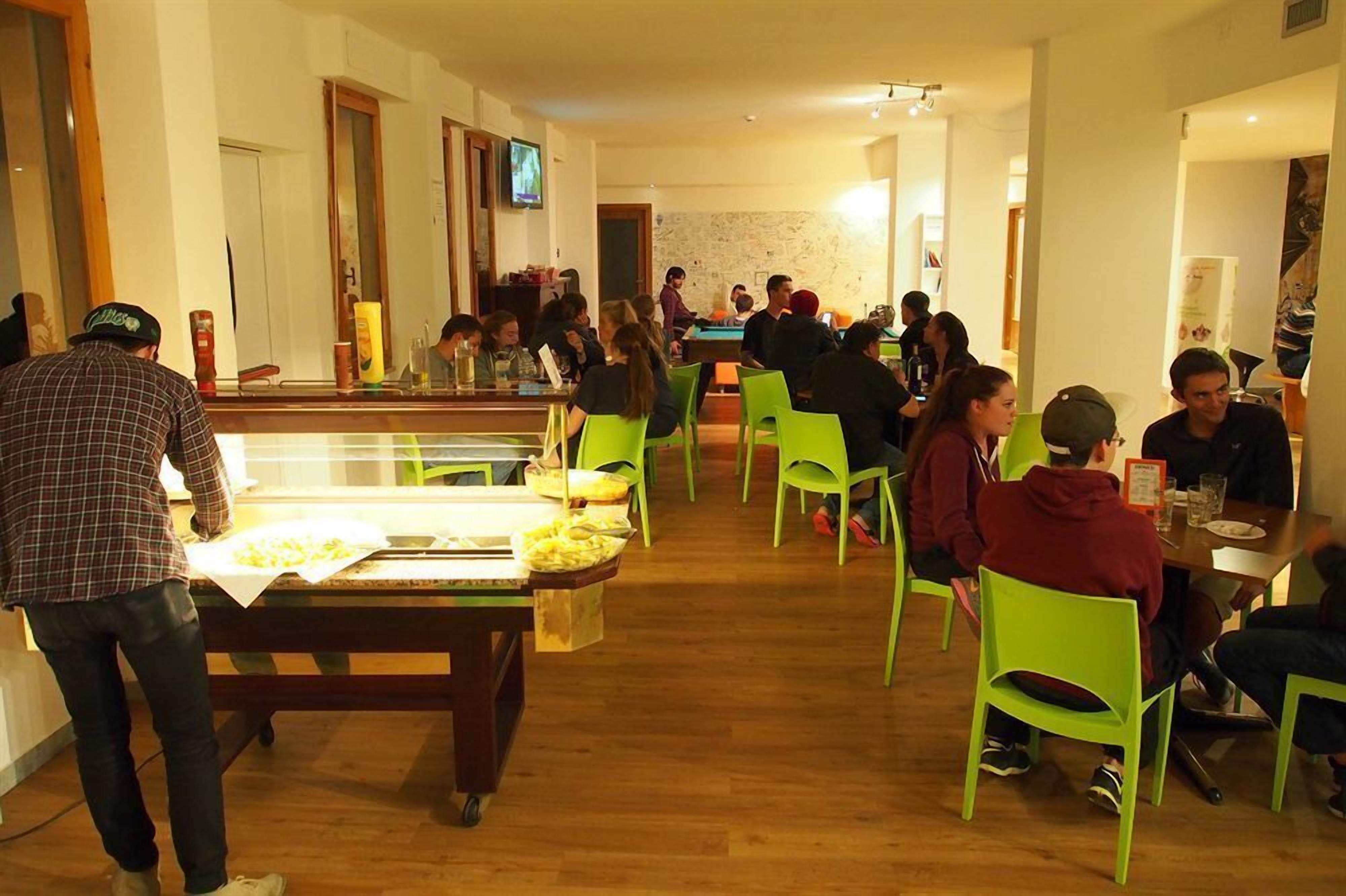 Un ristorante con pavimenti in legno e sedie verdi.