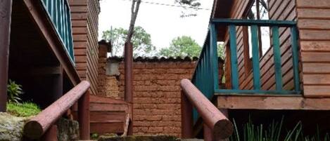Una escalera de piedra que lleva a edificios de madera con barandillas verdes.