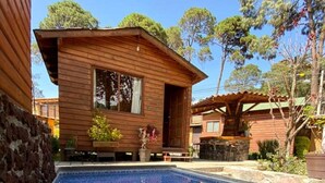 A wooden cabin with a swimming pool.