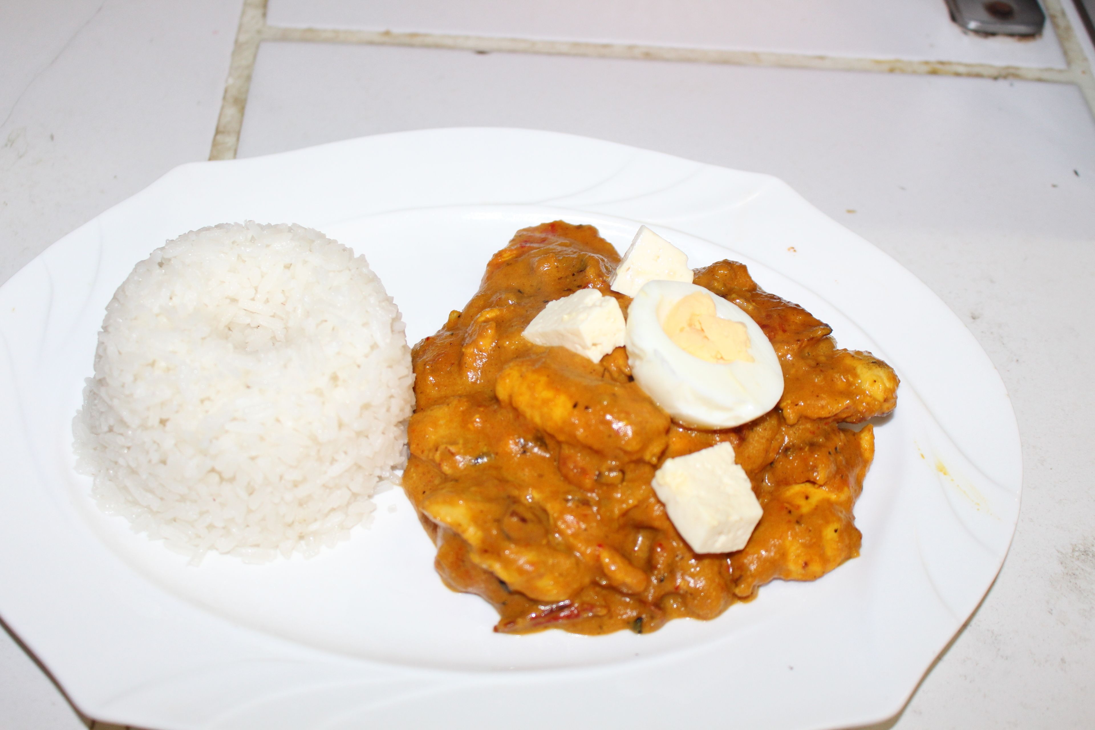 Un plato con arroz blanco y un curry con huevos cocidos.