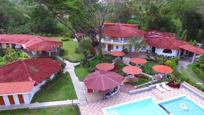 A resort with multiple buildings, a swimming pool, and outdoor umbrellas. - Hotel y Restaurante Valle Verde (El Valle de Anton)