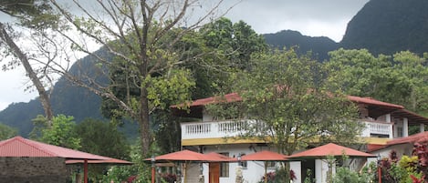 A hotel with a pool area, outdoor seating, and a mountain backdrop.