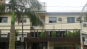 A building with a storefront, a balcony, and parked scooters.