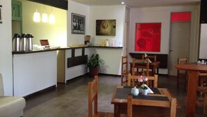 A modern kitchen with a bar area, wooden chairs, and a dining table.