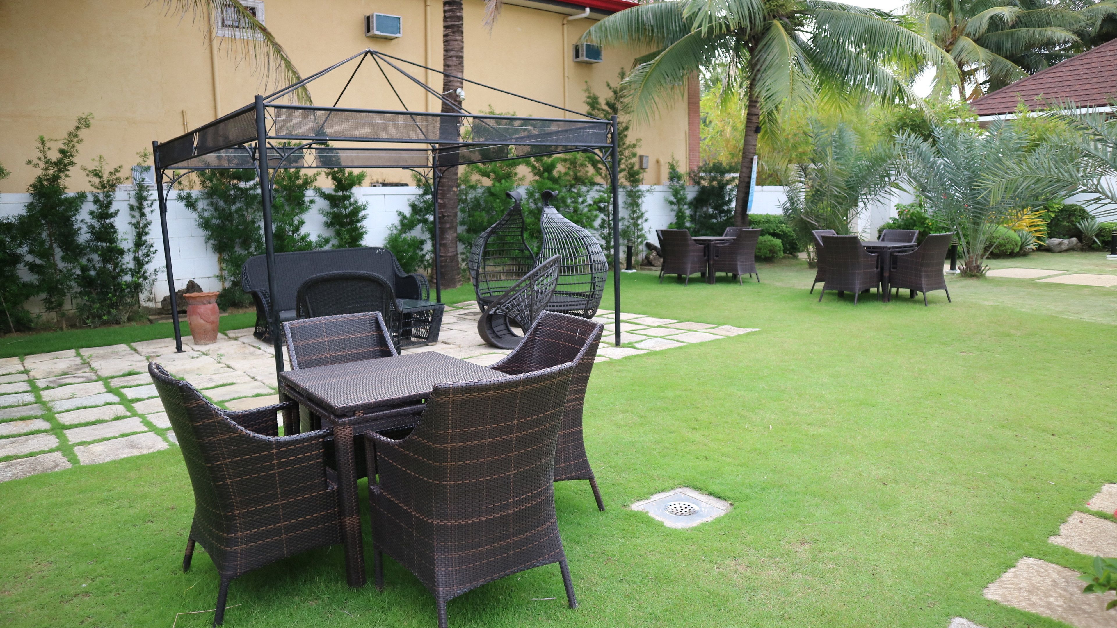 A patio with wicker furniture, a pergola, and a grill area.
