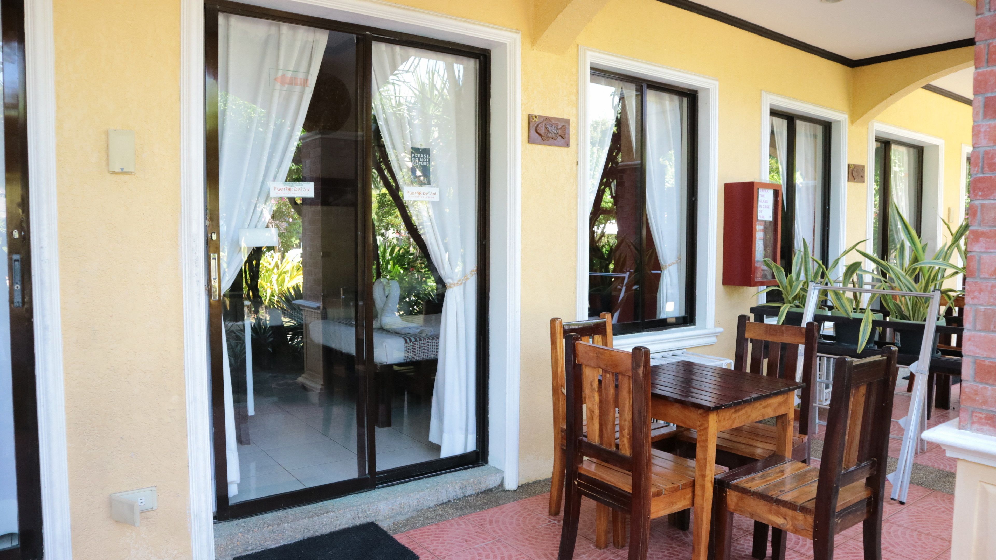 Un comedor con una mesa, sillas, un ventanal corredero y una pared de ladrillo.