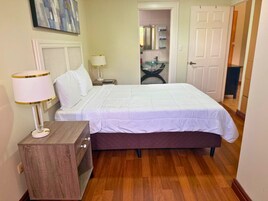 Un dormitorio con cama, mesitas de noche, lámpara y un armario de madera.