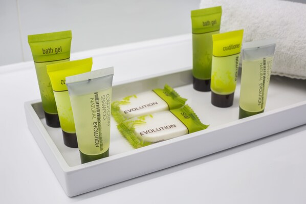 Tarjotin, jossa on erilaisia hygieniatuotteita, kuten suihkugeeliä, hoitoainetta ja shampoota.