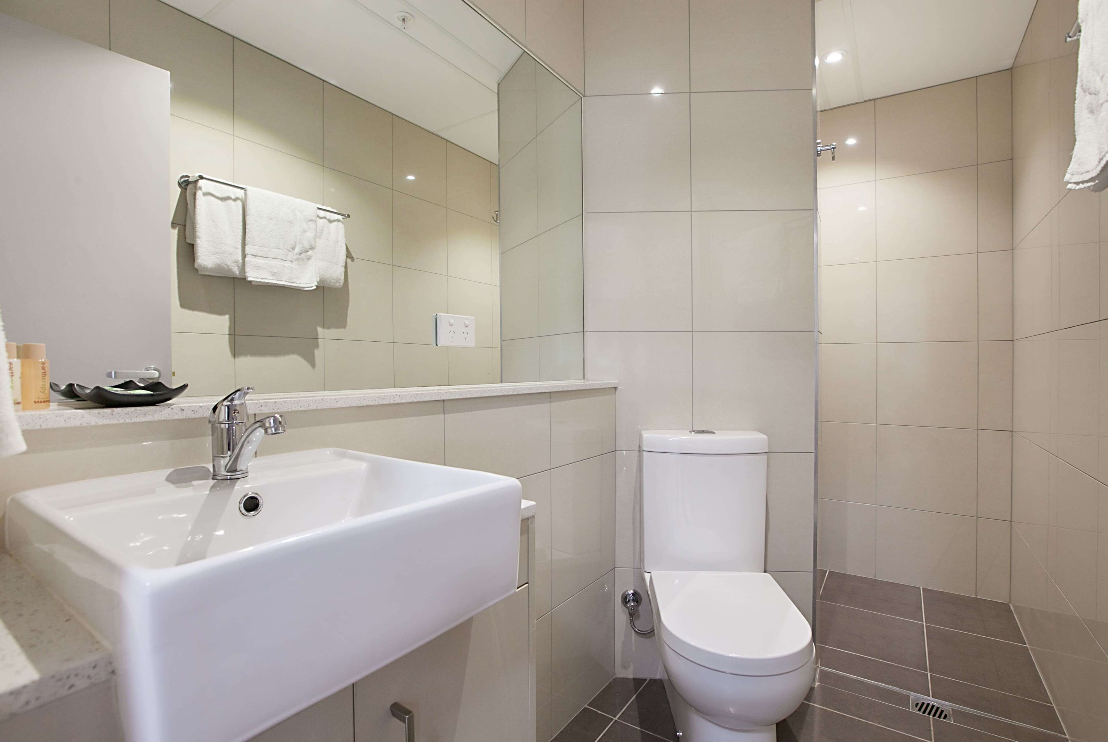 A bathroom with a white sink, a toilet, and a shower area.