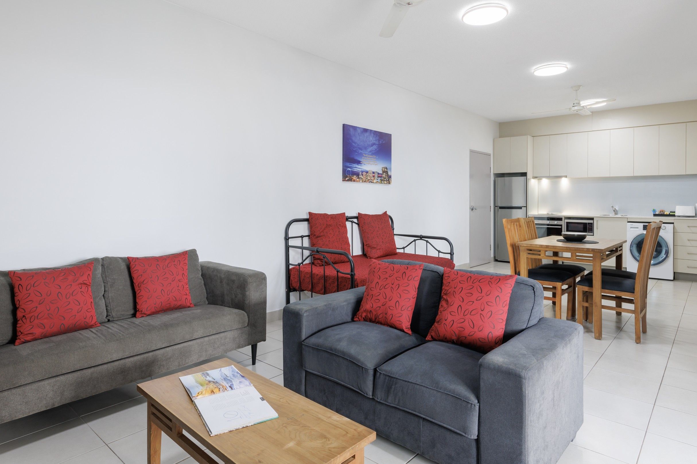 Uma sala de estar moderna com dois sofás, uma mesa de centro e um espaço de jantar com mesa e cadeiras.