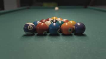Une table de billard avec un jeu de billes disposées en forme de triangle.