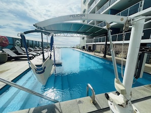 A pool area with lounge chairs and a canopy labeled "PELICAN POOL & SPA HOIST". - Ramada Suites by Wyndham Zen Quarter Darwin (Darwin)