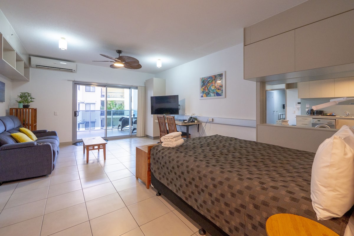 Une chambre d’hôtel moderne équipée d’un lit, d’un canapé, d’un bureau et d’une télévision.