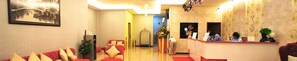 A hotel lobby with a reception desk, a sofa area, and a staircase leading to another floor. - Princeton Hotel (Johor Bahru)