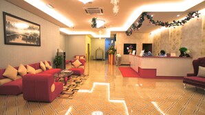 A hotel lobby with red sofas, a reception desk, and a large framed painting on the wall. - Princeton Hotel (Johor Bahru)