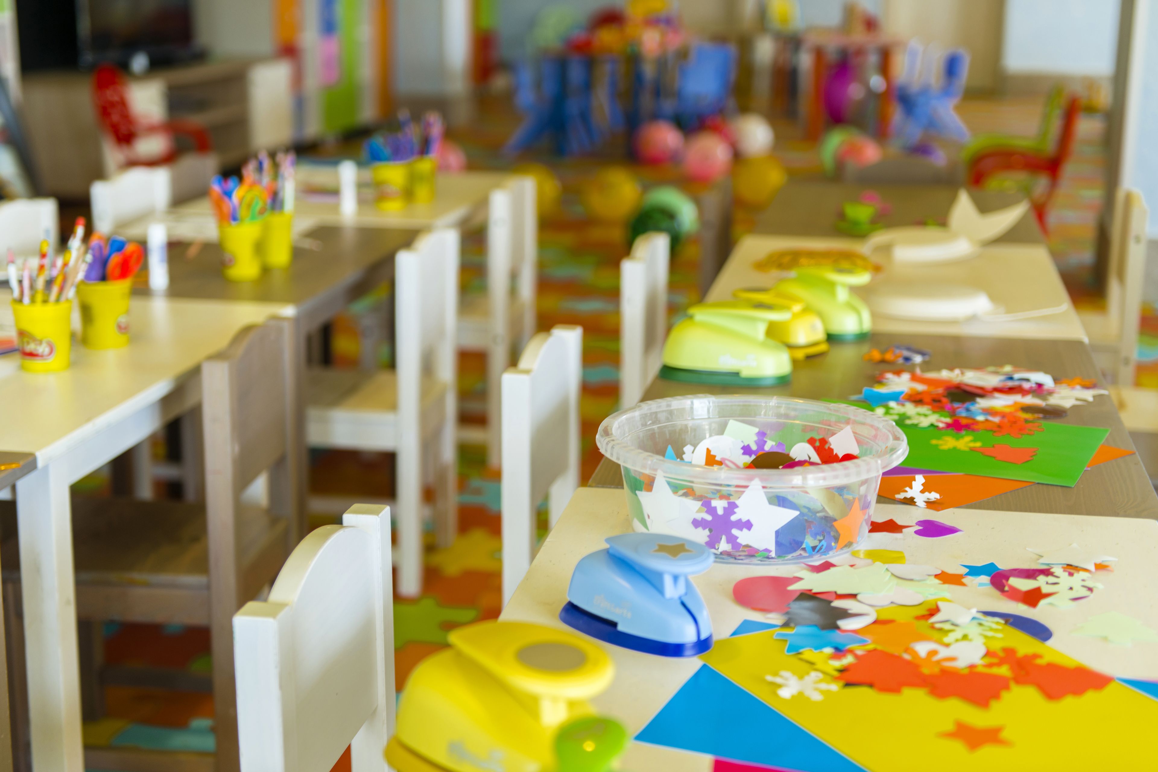 A classroom with tables, chairs, and craft supplies.