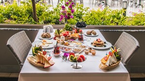 A table set for a meal with a view of a pool and palm trees. - Corendon Grand Park Lara - Ultra All Inclusive (Antalya)