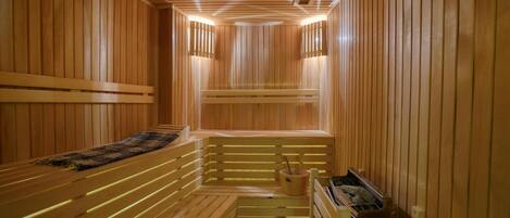 A wooden sauna with benches and a small table.