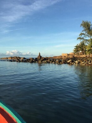 A rocky shoreline with calm water and a clear sky. - Maehaad Guesthouse (Ko Pha-ngan)