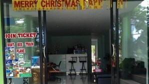 A building entrance with a 'Merry Christmas' sign, a glass door, and a tiled floor. - Maehaad Guesthouse (Ko Pha-ngan)