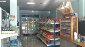 A grocery store interior with refrigerated sections, shelves stocked with snacks, and a display counter with packaged goods. - Maehaad Guesthouse (Ko Pha-ngan)