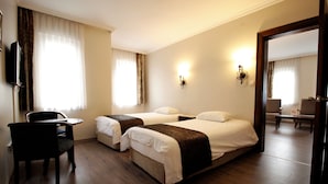 Une chambre d’hôtel avec deux lits, un bureau et une chaise.