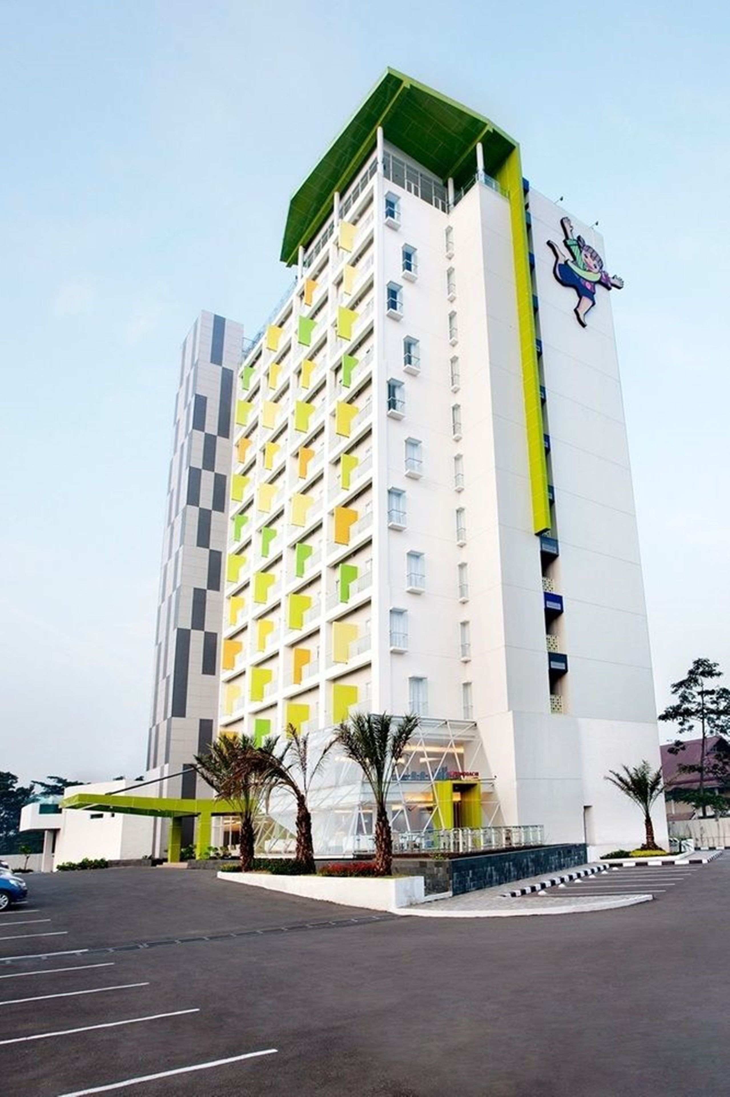 A modern hotel with a checkered facade, a green roof, and a cartoon character on the side.