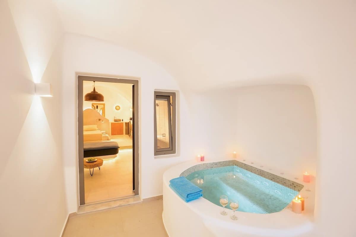Ein modernes Badezimmer mit einer freistehenden Badewanne, einem Spiegel und Kerzen.