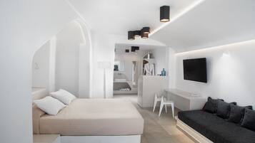 Une chambre à coucher moderne et minimaliste, comprenant un lit, un canapé, une télévision et un bureau.