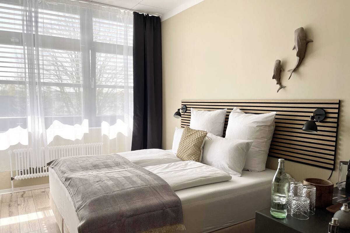 Ein Schlafzimmer mit Bett, Nachttisch, Lampe und Wanddekoration.