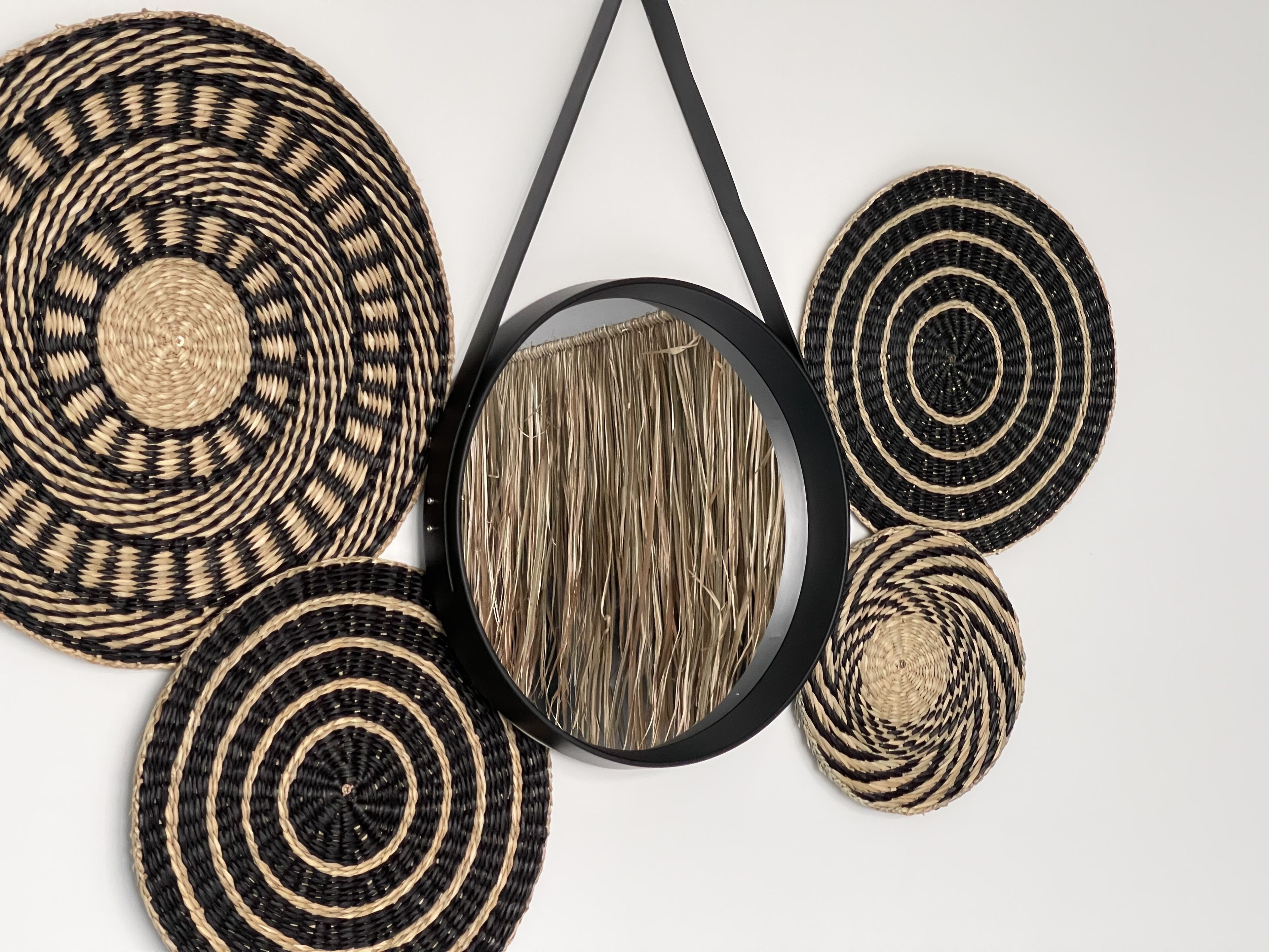 Une collection de dessous de verre tissés, de forme circulaire, disposés sur une surface blanche.