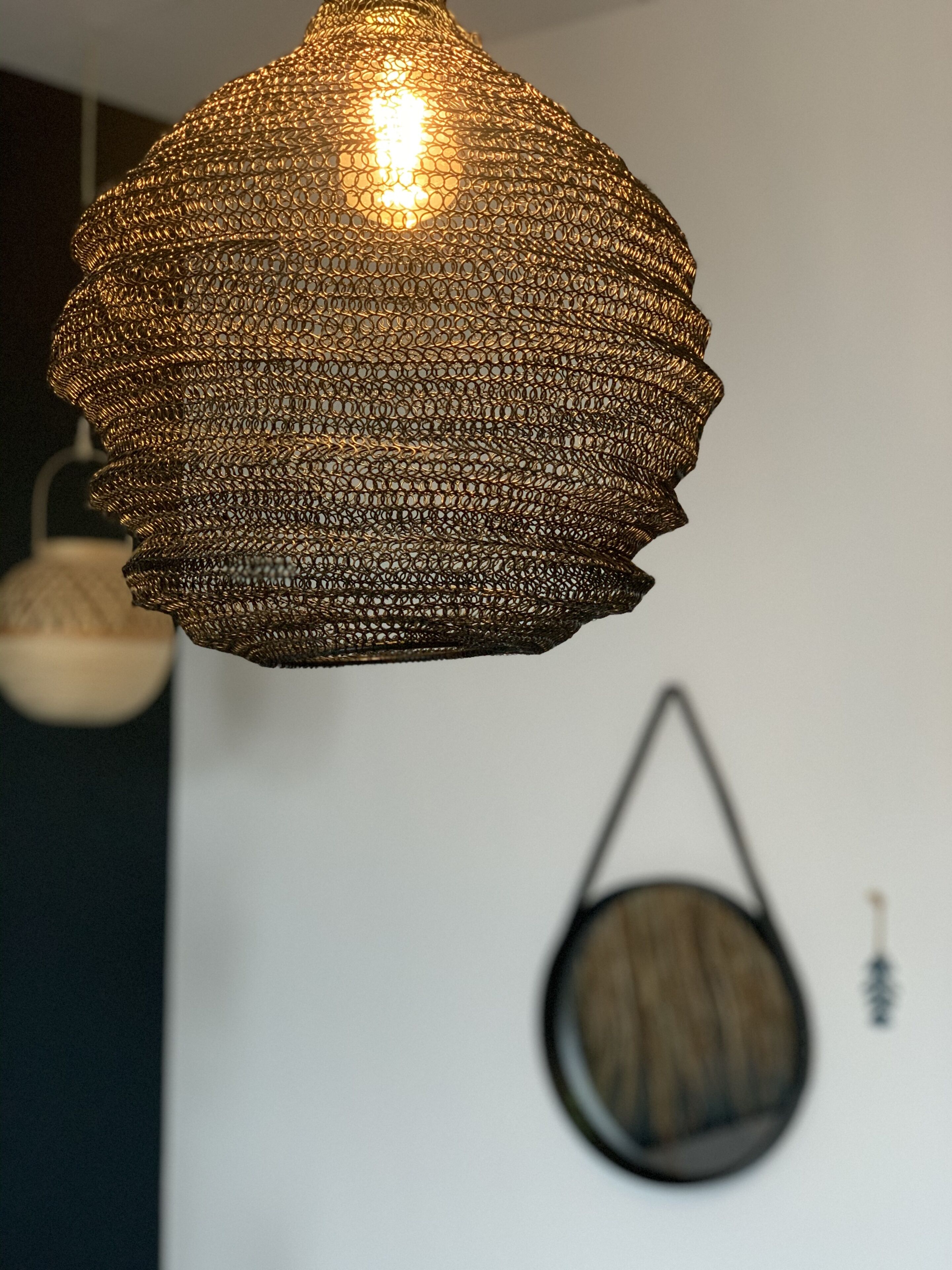 A hanging light fixture with a textured, metallic design.