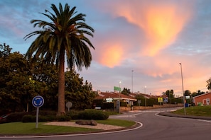 A motel with a garden sign, a palm tree, and a clear sky. - Motel Jardin (Oleiros)