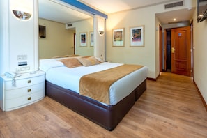A hotel room with a large bed, bedside tables, a mirror, and framed artwork on the wall. - Motel Jardin (Oleiros)