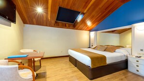 A modern bedroom with a wooden ceiling, a large bed, a desk, and a chair. - Motel Jardin (Oleiros)