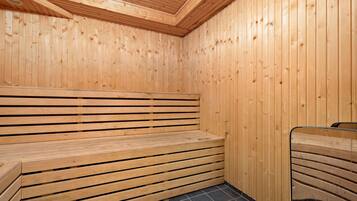 Uma sauna de madeira com bancos e piso revestido de azulejos.
