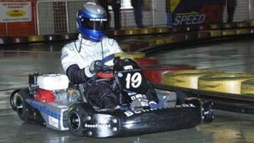 A go-kart racer in a go-kart with the number 19, racing on a track.