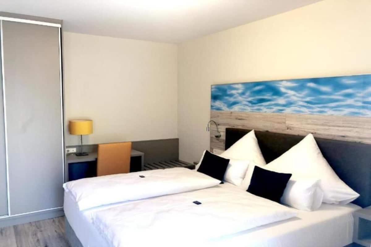 Una habitación de hotel con cama, escritorio y silla.