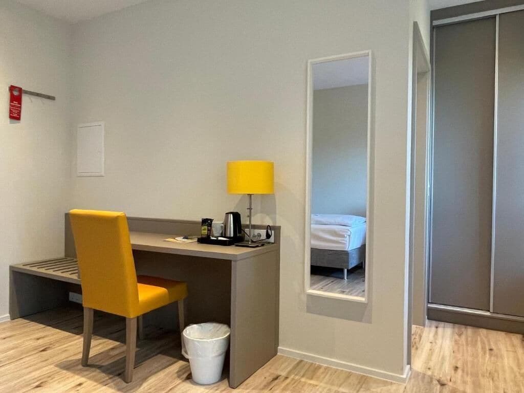 Habitación de hotel con escritorio, silla, lámpara y cama con vistas.